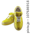 Infinitely beautiful leather sneakers made of canary yellow genuine leather, on a polyurethane translucent sole, with lacing, isolated on a white. 107686918