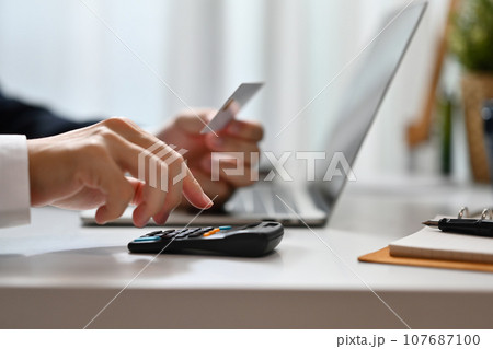 Cropped shot of man calculating expenses and debt from credit cards. E-commerce, financial planning and expenses Cropped shot of man calculating expenses and debt from credit cards. E-commerce, financial planning and expenses 107687100