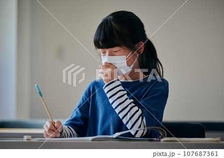 風邪をひいて咳をする小学生の女の子 107687361