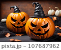 Orange pumpkin with a scary face wearing a black witch hat on Halloween. 107687962