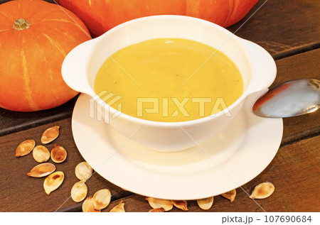 Pumpkin hot puree soup on a wooden table 107690684