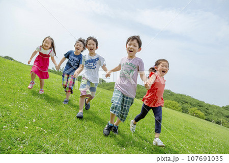 公園の草地で遊ぶ小学生たち 公園の草地で遊ぶ小学生たち 107691035