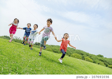 公園の草地で遊ぶ小学生たち 公園の草地で遊ぶ小学生たち 107691036