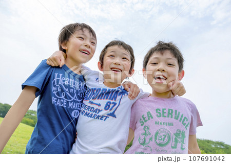 公園の草地で遊ぶ小学生たち 107691042