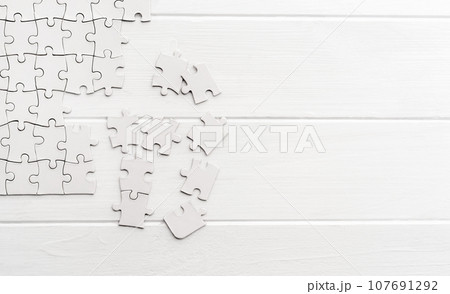 Pieces of empty jigsaw puzzle 107691292