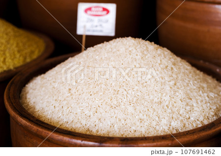 Pile of raw rice in bowl Pile of raw rice in bowl 107691462