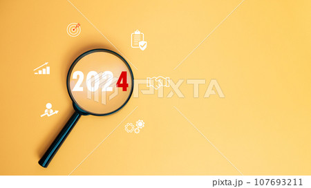 Magnifying glass focused on letter 2024 on yellow background. Represents setting goals for 2024, Startup concept. Financial planning, development, Business strategy, Setting business goals. Magnifying glass focused on letter 2024 on yellow background. Represents setting goals for 2024, Startup concept. Financial planning, development, Business strategy, Setting business goals. 107693211