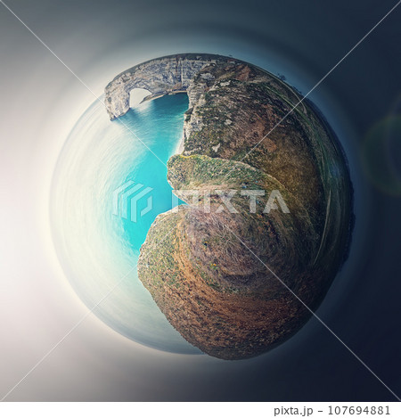 Sightseeing panoramic view to the Porte d'Aval arch cliff as a micro planet in space. Ocean waters continental side of Etretat, Normandy, France. Beautiful coastline scenery of famous Falaise d'Aval 107694881