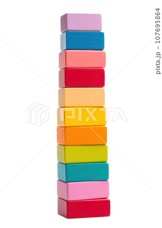 Colorful blocks stacked high in a tower, ready to topple isolated Colorful blocks stacked high in a tower, ready to topple isolated 107695864
