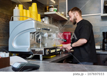 Young male barista preparing coffee in coffee shop Young male barista preparing coffee in coffee shop 107697033