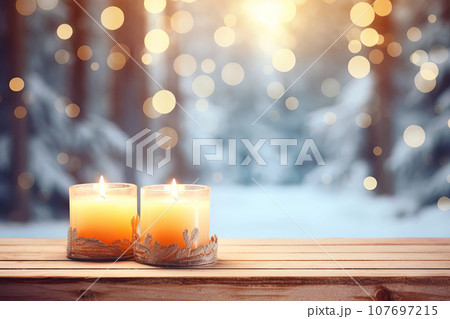 Empty table top with burning candles on blurred festive winter forest background 107697215