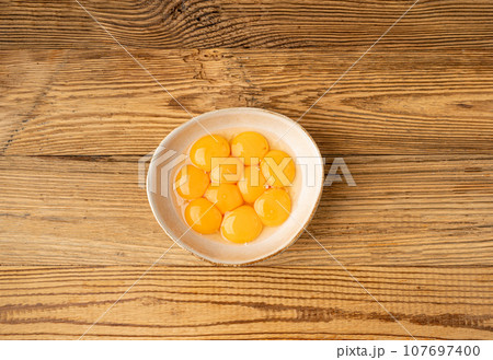 Egg Yolks in Bowl, Fresh Chicken Egg Yolk Separated from Whites for Cooking Recipe, Organic Yolks Top View 107697400