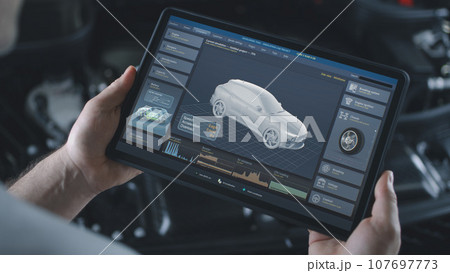 Male technician holds tablet with simulation of car diagnostics and aerodynamics 107697773