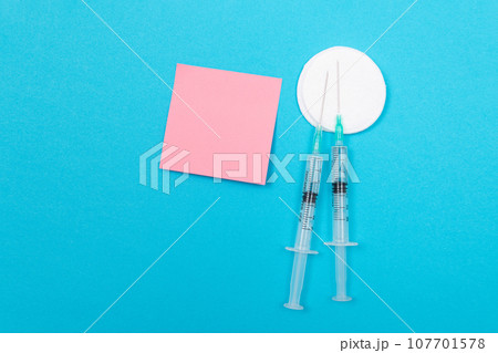 Vaccination or Revaccination Concept - Two Medical Syringe on Blue Table Vaccination or Revaccination Concept - Two Medical Syringe on Blue Table 107701578