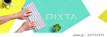 Woman using a computer keyboard Woman using a computer keyboard 107701973