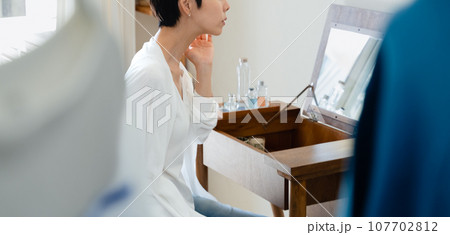 部屋で外出準備をする女性 107702812