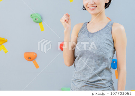 ボルダリングジムでガッツポーズをする女性 ボルダリングジムでガッツポーズをする女性 107703063