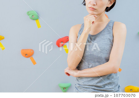 ボルダリングジムで考え事をする女性 ボルダリングジムで考え事をする女性 107703070