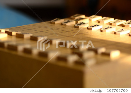 明るい光の中の将棋盤の上に並んだ将棋の駒 明るい光の中の将棋盤の上に並んだ将棋の駒 107703700