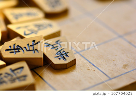 将棋盤の上に重なった将棋の駒 将棋盤の上に重なった将棋の駒 107704025