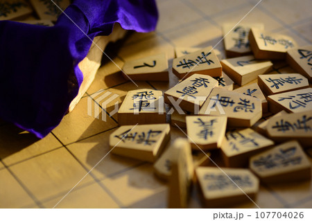 将棋盤の上に重なった将棋の駒 将棋盤の上に重なった将棋の駒 107704026