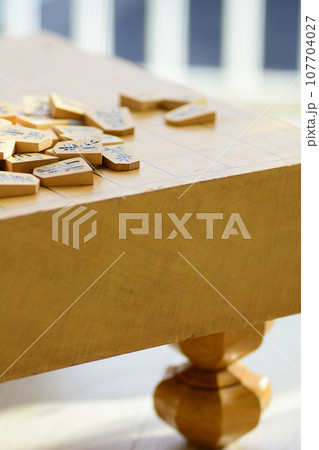 将棋盤の上に重なった将棋の駒 107704027