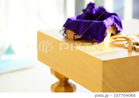 明るい部屋に置かれた将棋盤と将棋の駒 107704060