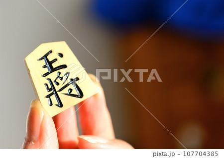 手で持った王将の駒 手で持った王将の駒 107704385