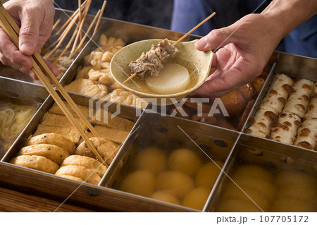 熱々のおでんを箸ですくう料理人 熱々のおでんを箸ですくう料理人 107705172