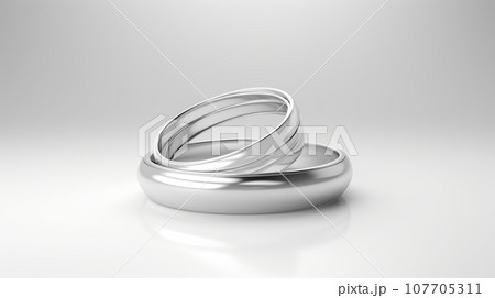 Two silver wedding bands intertwined on a white background. This image symbolizes love, commitment, and marriage. The rings are simple and elegant, reflecting a timeless and classic style. Two silver wedding bands intertwined on a white background. This image symbolizes love, commitment, and marriage. The rings are simple and elegant, reflecting a timeless and classic style. 107705311
