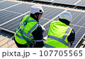 Engineers with safety helmet checking solar system at solar power farm 107705565