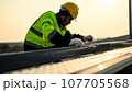 Engineer worker working at solar cell power plant with sunset 107705568