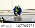 Maintenance technicians installing solar panels at solar cell farm 107705575