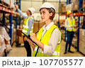 Engineer with safety vest using tablet checking goods on shelves 107705577