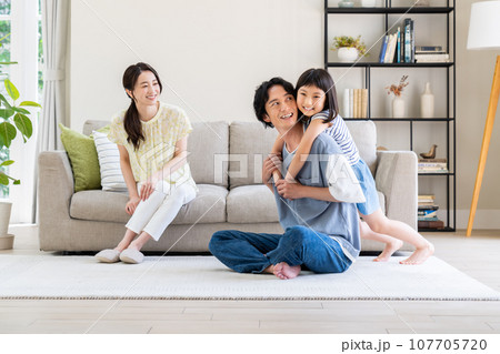 リビングでくつろぐ若い家族 リビングでくつろぐ若い家族 107705720