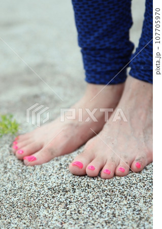 女性の足と砂浜 107705970