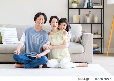 リビングでくつろぐ若い家族 リビングでくつろぐ若い家族 107707697