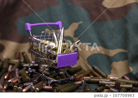 Rifle cartridges in small shopping cart. Big caliber ammo cartridges with a small shopping basket Rifle cartridges in small shopping cart. Big caliber ammo cartridges with a small shopping basket 107708963