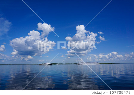 Summer landscape on the river with clouds in the blue sky Summer landscape on the river with clouds in the blue sky 107709475