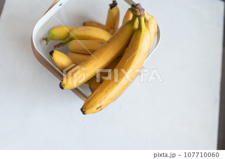 Ripe yellow fruit bananas in decorative bag. White background. Top view. Tropical sweet food 107710060