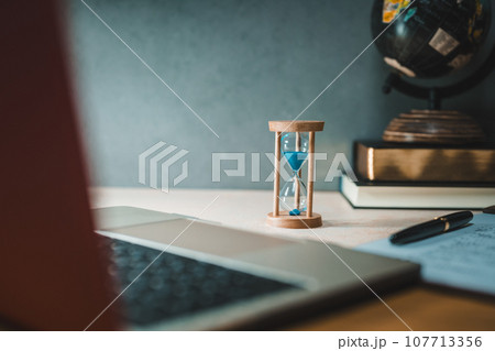 机に置かれた砂時計 107713356