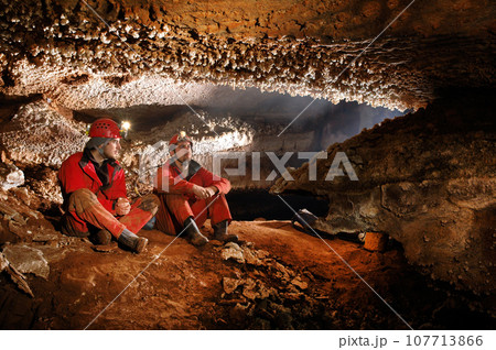 Speleologists exploring a beautiful cave 107713866