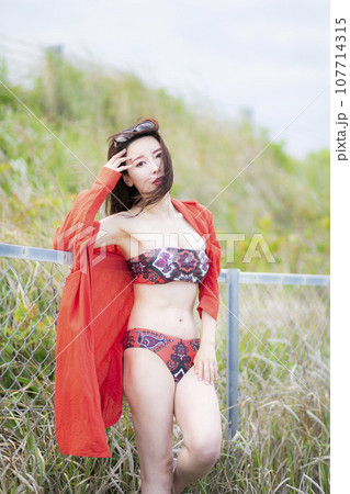 赤いビキニ姿の美人ミセス 107714315