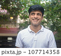 Smart Indian man in white standing outdoors 107714358