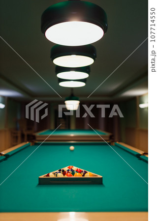 Billiard accessories balls and cue on a billiard table room 107714550