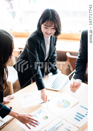 会議室で熱心に打ち合わせをするビジネスチーム 107717742