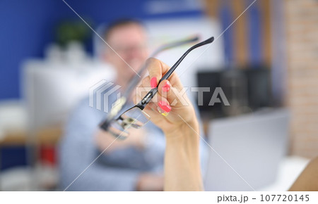 Woman's hand with bright nails holds glasses Woman's hand with bright nails holds glasses 107720145
