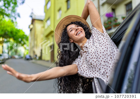 Young girl traveling by car, hispanic woman with curly hair looking out the window, enjoying vacation and travel. Young girl traveling by car, hispanic woman with curly hair looking out the window, enjoying vacation and travel. 107720391