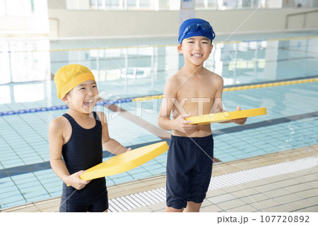 室内プールでビート板を持って笑う兄弟 室内プールでビート板を持って笑う兄弟 107720892