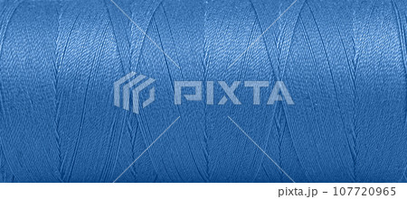 Texture of threads in a spool of blue color on a white background 107720965